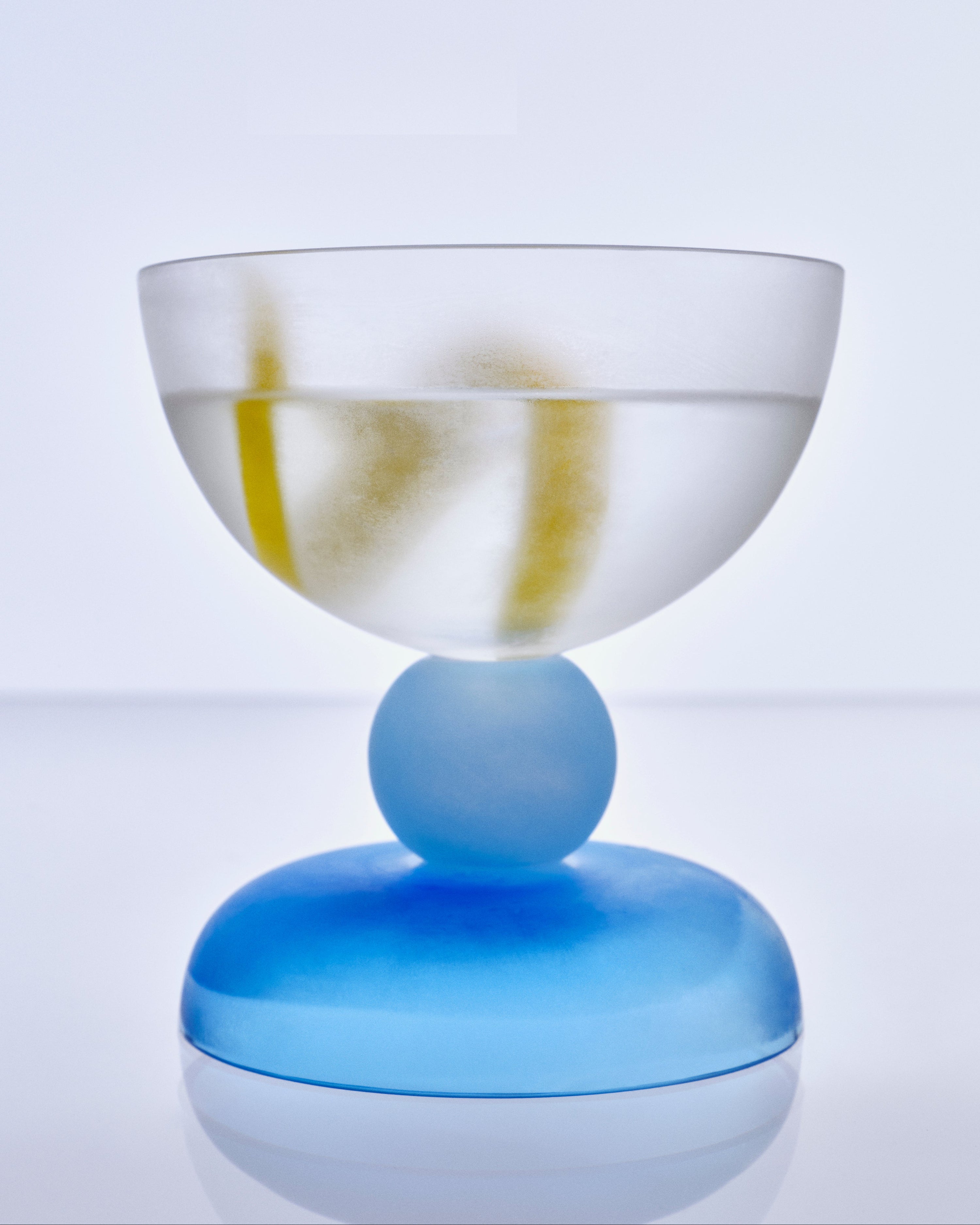 Glass cocktail coupe with a blue base and clear bowl 